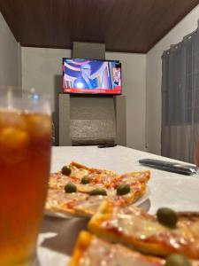 a table with two slices of pizza and a glass of beer at MonSua in San Luis