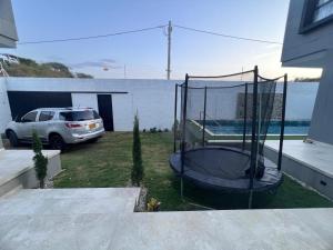 a car parked in a yard with a trampoline at Villa Sabanilla Casa bifamiliar campestre con piscina privada Aire acondicionado Tranquilidad total in Puerto Colombia