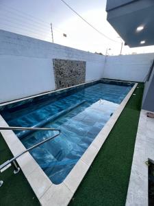 a swimming pool with blue water in a building at Villa Sabanilla Casa bifamiliar campestre con piscina privada Aire acondicionado Tranquilidad total in Puerto Colombia