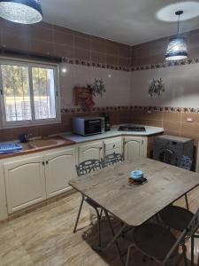a kitchen with a wooden table and a table and chairs at Dar Karim in Midoun
