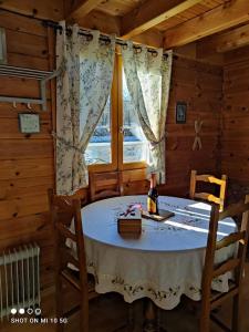 a dining room with a table and a bottle of wine at Chalet Le Gentiane in Bun
