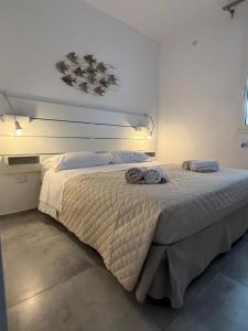 a bedroom with a large bed with two towels on it at Arneo Rooms in Torre Lapillo