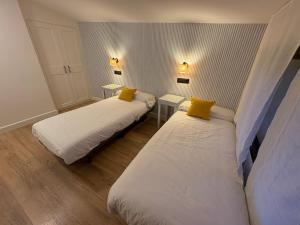 two beds with yellow pillows in a room at Finca Alboroto in Huesca +39 photos