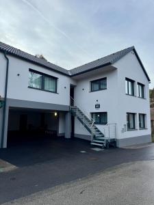 a white house with a garage and a staircase at Erdeis Apartments in Krems an der Donau