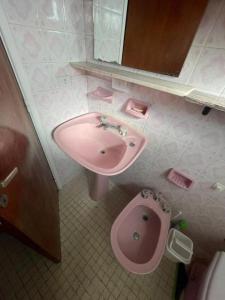 a bathroom with a pink sink and a toilet at PH con cochera cubierta cerca de la playa in Villa Gesell +2 photos