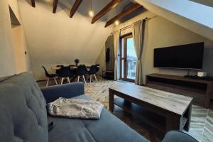 a living room with a couch and a tv and a table at Na Fali Marszałka in Mielenko