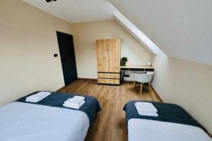 a room with two beds and a desk in it at Na Fali Marszałka in Mielenko