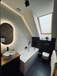 a bathroom with a large white tub and a window at Na Fali Marszałka in Mielenko +14 photos