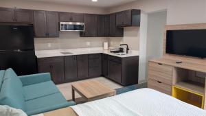 a kitchen with brown cabinets and a blue chair in a room at Days Inn by Wyndham Champaign/Urbana in Champaign +8 photos