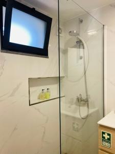 a bathroom with a shower with a television on the wall at Cozy House in Funchal +35 photos