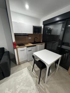 a small kitchen with a white table and a table and chairs at Studio 2 personnes maximum in Saint-Andiol +5 photos