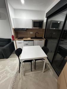 a white table and chairs in a small kitchen at Studio 2 personnes maximum in Saint-Andiol