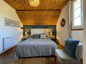 ein Schlafzimmer mit einem Bett und einem Stuhl in der Unterkunft Atchouetos in Aramits
