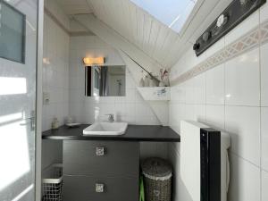 ein kleines Badezimmer mit Waschbecken und Spiegel in der Unterkunft Atchouetos in Aramits + 30 Fotos