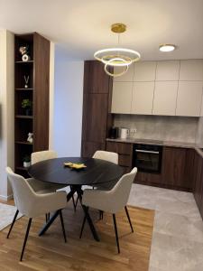 a dining room with a black table and chairs at Stelmar Apartment in Banja Luka