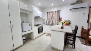 a kitchen with white cabinets and a counter top at The Ideal Bed & Breakfast in Nadi +37 photos