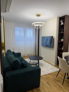 a living room with a green couch and a table at Stelmar Apartment in Banja Luka