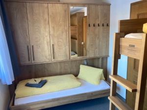 a bunk bed with a cabinet and two pillows at Pension Haus Georg in Westendorf