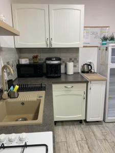 a kitchen with white cabinets and a sink at Casa JOY in Râşnov