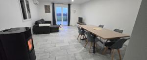a living room with a dining table and a television at Lauberge de Villeron in Savigny-en-Revermont