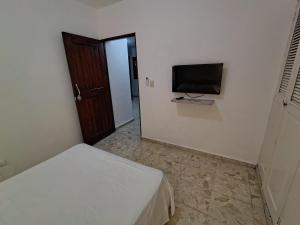 a bedroom with a bed and a flat screen tv at Comfortable and quiet double room in Santo Domingo