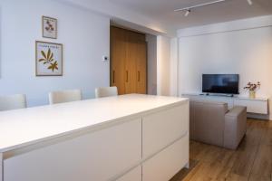 an office with a white desk and a tv at Mirror Apartments in Satu Mare