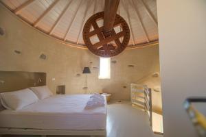 a bedroom with a bed and a large ceiling at Traditional Windmill House , Chora Serifos in Serifos Chora
