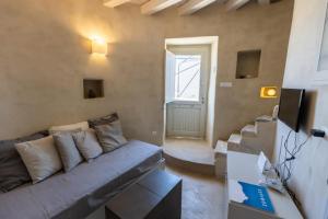 a living room with a gray couch and a window at Traditional Windmill House , Chora Serifos in Serifos Chora