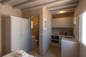 a kitchen with white cabinets and a sink at Traditional Windmill House , Chora Serifos in Serifos Chora