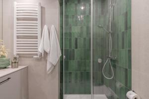 a bathroom with a shower with green tile at Harbor Apartments - Aparthotel przy Rynku in Katowice +84 photos