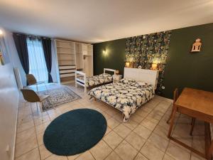 a bedroom with a bed and a chair and a table at Moulin de Montizeau in Saint-Maigrin