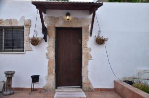 a wooden door on a white building with a lamp at Sweet Little House in Acre