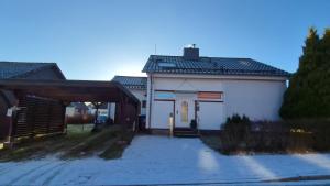 a white building with a garage and a driveway at Haus Ferien Bock in Clausthal-Zellerfeld