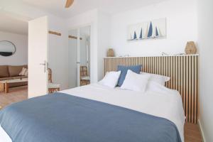 a bedroom with a large bed with blue and white pillows at Wohnung Rio in Calpe