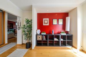 a living room with a red accent wall at Nazare House4you in Nazaré