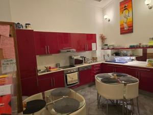 a kitchen with red cabinets and a table and chairs at Budapest B&B Bed and Breakfast in Budapest +31 photos