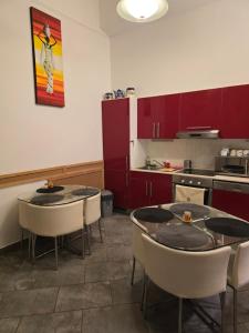 a kitchen with two tables and chairs and red cabinets at Budapest B&B Bed and Breakfast in Budapest