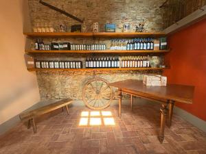 a table and bench in a room with a stone wall at Podere Casato in Montespertoli