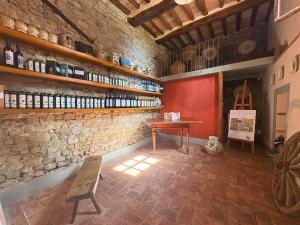a room with a bench and a table and a brick wall at Podere Casato in Montespertoli