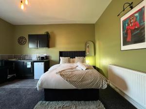 a bedroom with a bed and a kitchen at Hayy Studio Quiet Comfy Connected in Huddersfield