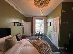 a bedroom with a bed and a chandelier at Hayy Studio Quiet Comfy Connected in Huddersfield