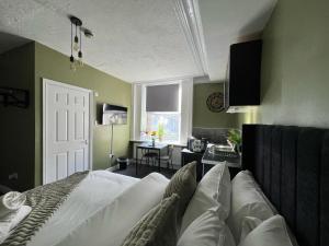 a bedroom with a bed and a desk and a window at Hayy Studio Quiet Comfy Connected in Huddersfield +23 photos