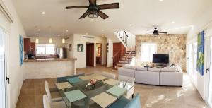 a dining room and living room with a ceiling fan at Experience Luxury on Isla Mujeres! in Isla Mujeres