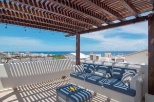 a patio with a couch and a view of the ocean at Experience Luxury on Isla Mujeres! in Isla Mujeres