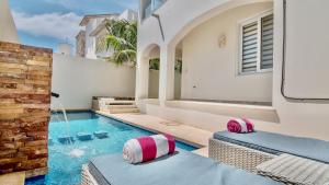 a swimming pool with pink and white pillows in a house at Experience Luxury on Isla Mujeres! in Isla Mujeres