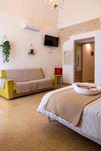 two beds in a room with a tv on the wall at Le Gravinelle - Apulia Houses & Flats in Ruvo di Puglia