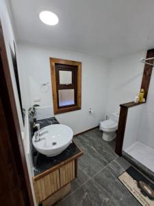 a bathroom with a sink and a toilet at Casa Arrayan in Coñaripe +6 photos
