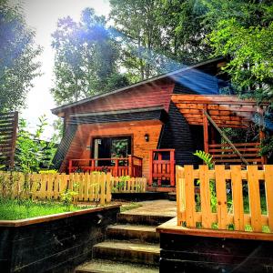 a small log cabin with a wooden fence at Casa Arrayan in Coñaripe