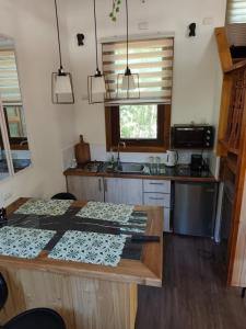 a kitchen with a table and a counter top at Casa Arrayan in Coñaripe