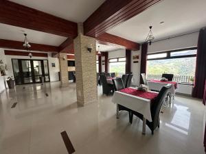 a dining room with a table and chairs and windows at Pensiunea Magura in Măgura